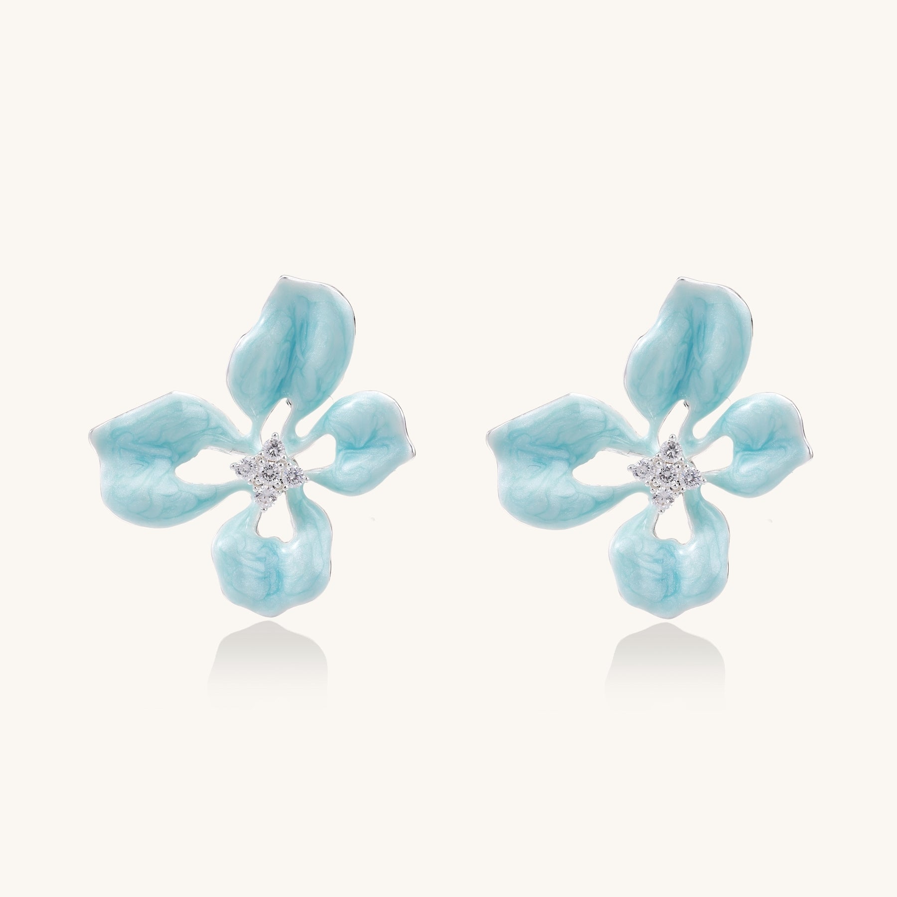 Turquoise blue enamel flower earrings with crystal centers and gold-plated brass posts on white background.