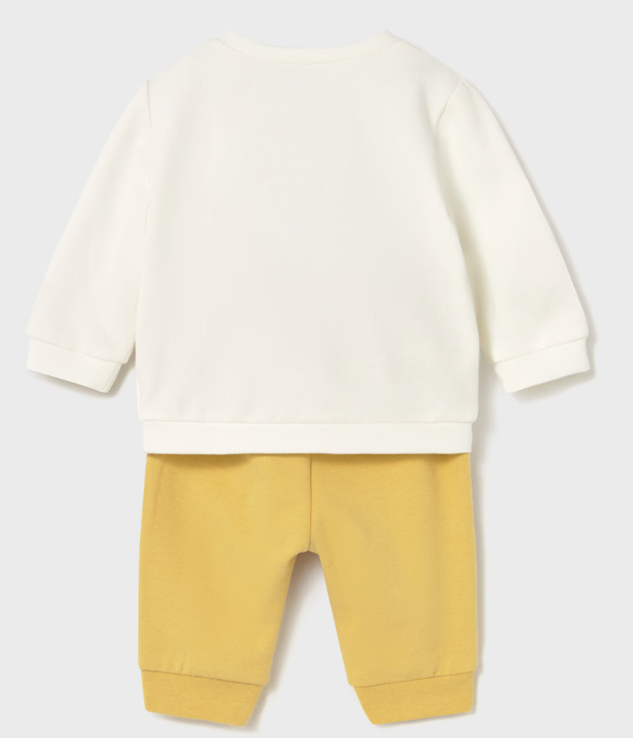Backside view of Mayoral dino set baby outfit with white long-sleeve shirt and yellow pants on a light gray background