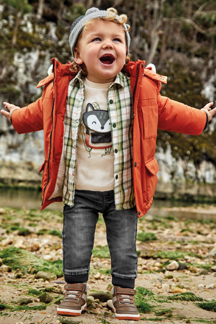 Little boy wearing Mayoral grey denim jogger with his arms open