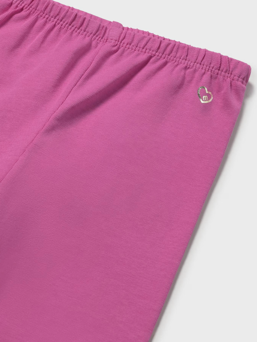 Close-up of pink pants with a brand logo on a light gray background