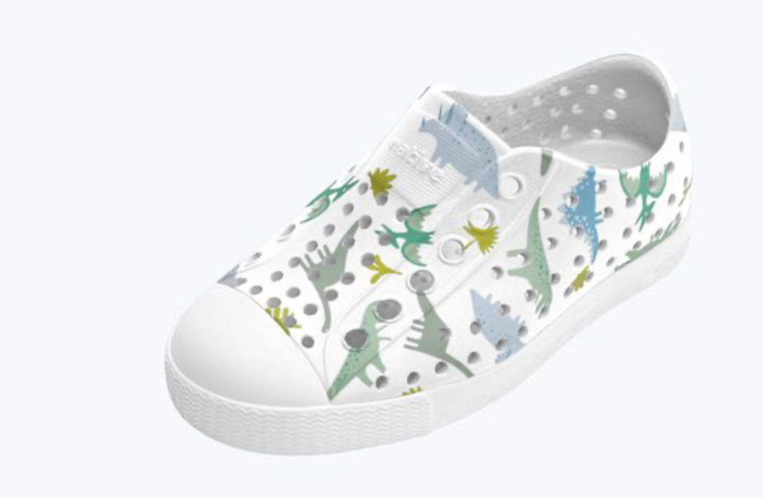 White clog shoe with dinosaur pattern on a white background