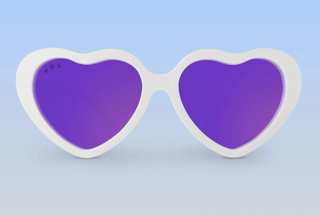 A pair of Ro Sham Bo white heart-shaped sunglasses with purple polarized lenses against a blue background.