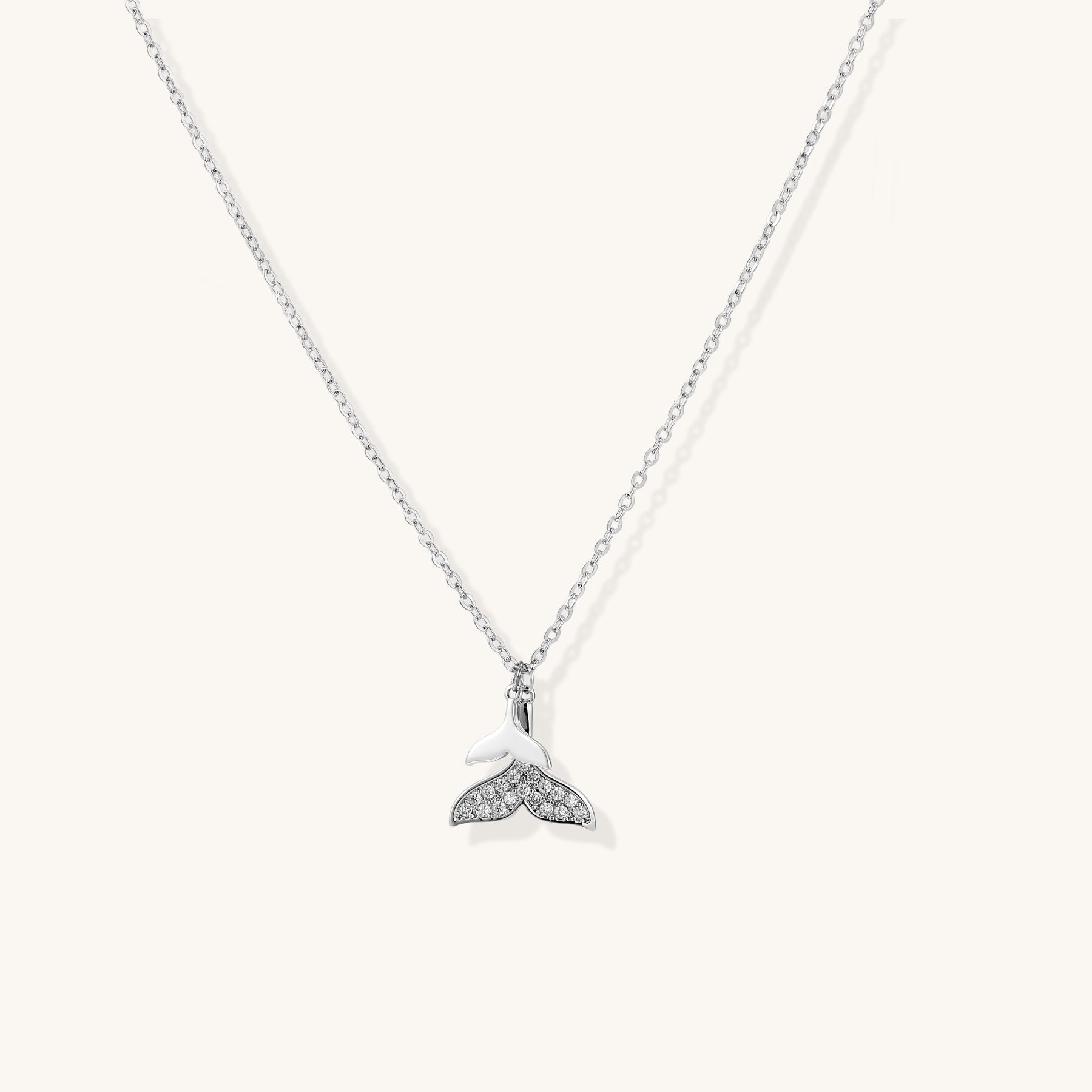 Delicate 14K gold-plated whale tail pendant necklace with sparkling crystal details on fine chain against white background.