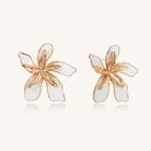 Large floral stud earrings with gold-plated brass petals and white enamel centers on neutral background