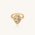 Gold-plated heart ring with turquoise enamel scrollwork and cubic zirconia stones on white background