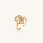 Gold-plated heart ring with turquoise enamel scrollwork and cubic zirconia stones on white background