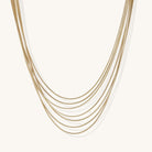 Multiple delicate gold-plated snake chains in graduated lengths on white background, adjustable layered necklace design.