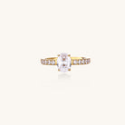 14K gold-plated ring with oval zirconia center stone and pavé band accent stones on white background.