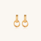 Geometric gold earrings with ribbed linear top section and circular drop elements on white background.