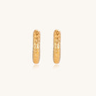 Textured gold-plated hoop earrings with dimpled surface pattern and post backs on neutral background.
