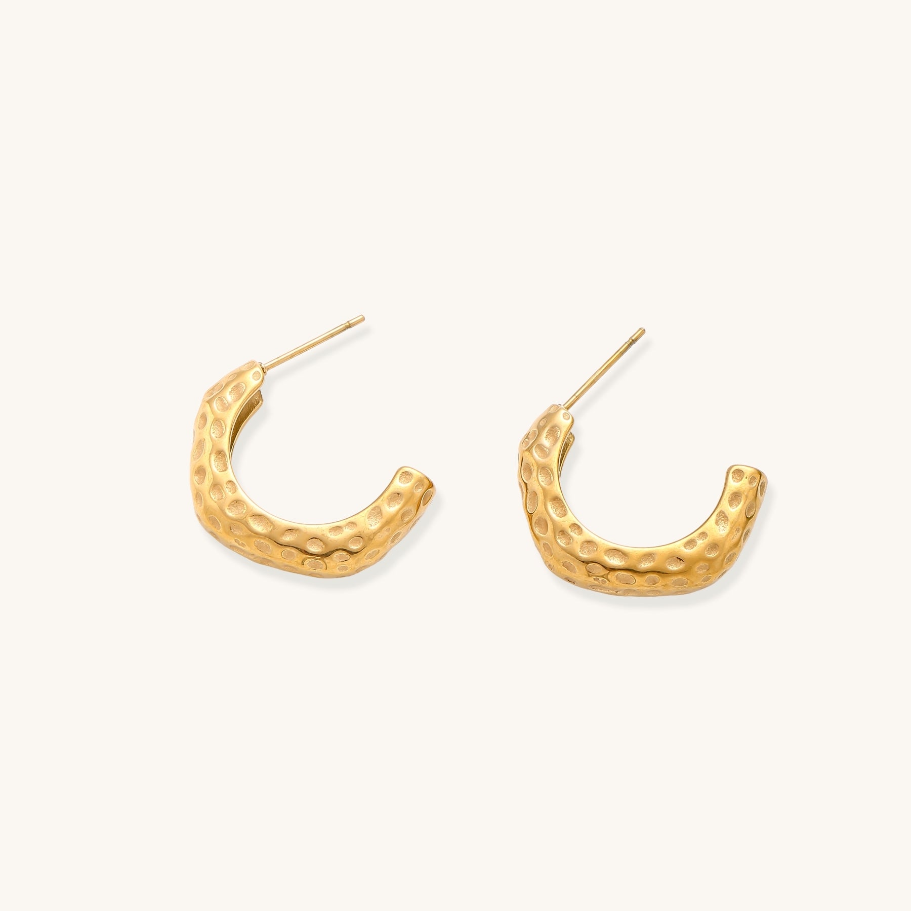 Textured gold-plated hoop earrings with dimpled surface pattern and post backs on neutral background.