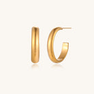 Four pairs of gold-plated stainless steel earrings including hoops and studs displayed on cream background