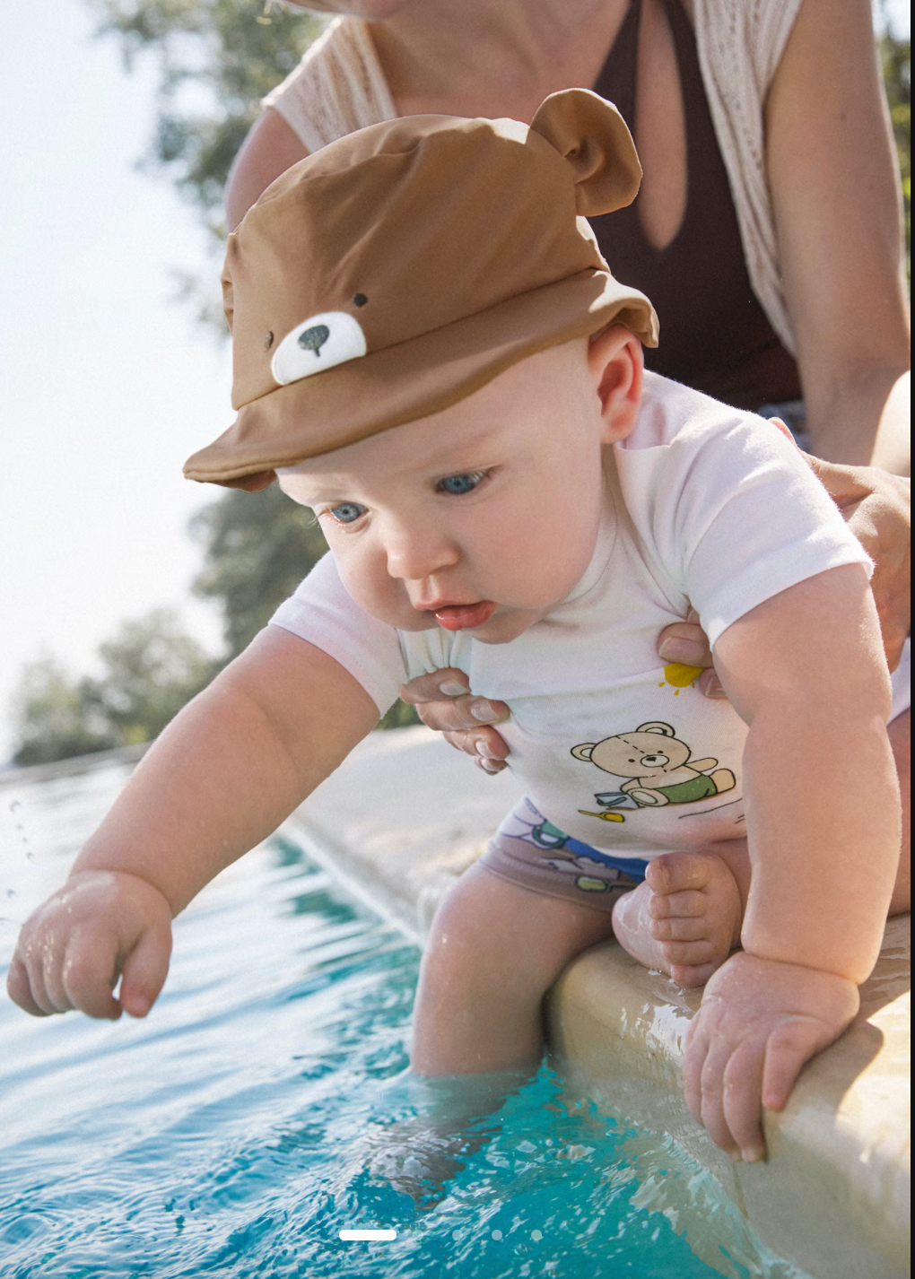 Baby wearing 3-piece swim set playing in water