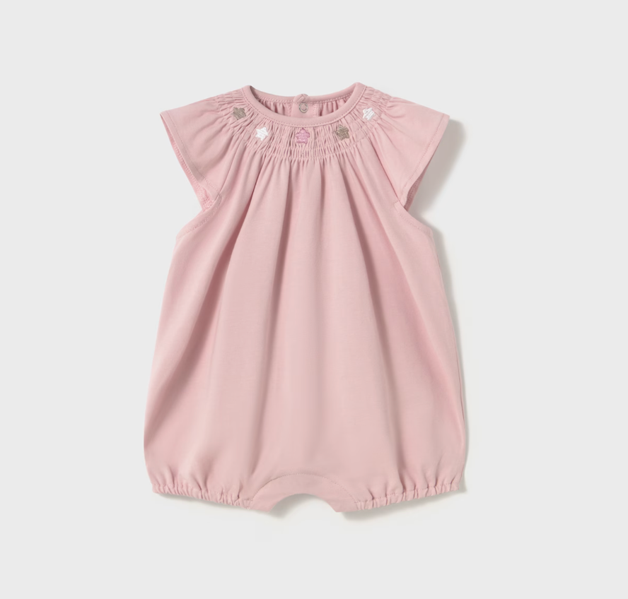 A sleeveless pink romper with ruffles for babies, featuring button closures at the back and crotch.
