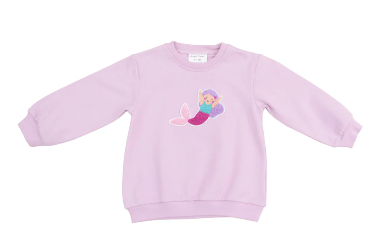 An oversized pink sweatshirt with a colorful mermaid applique on the front.