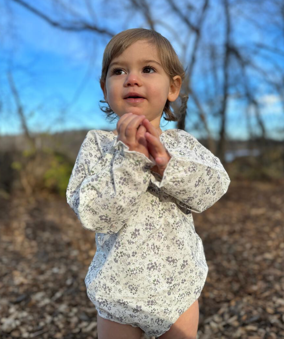 Little girl wearing a bubble floral onesie from Vignette